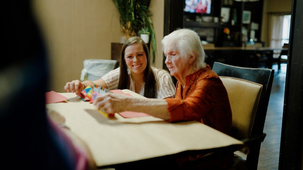 A woman is going through a memory care therapy session with a nurse