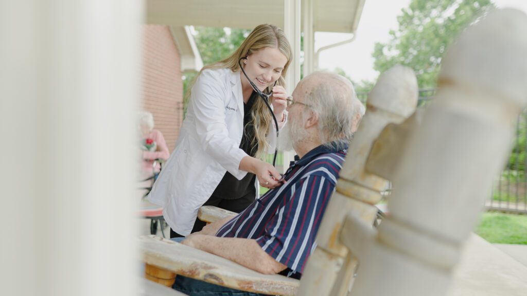 A nurse assists a man at a skilled nursing facility