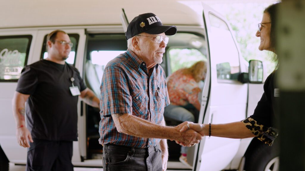 A man shakes hands with a North Hills staff worker for respite care services